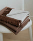 Brown and beige plaid blanket on a white chair