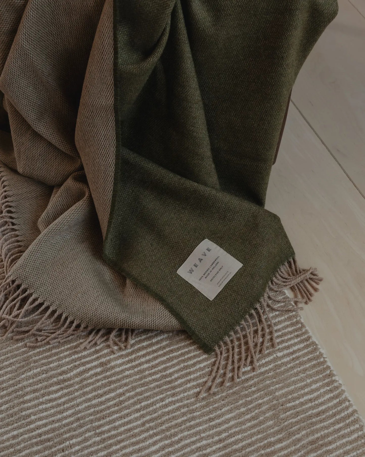 Green plaid blanket with a label on a wooden floor