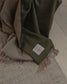 Green plaid blanket with a label on a wooden floor