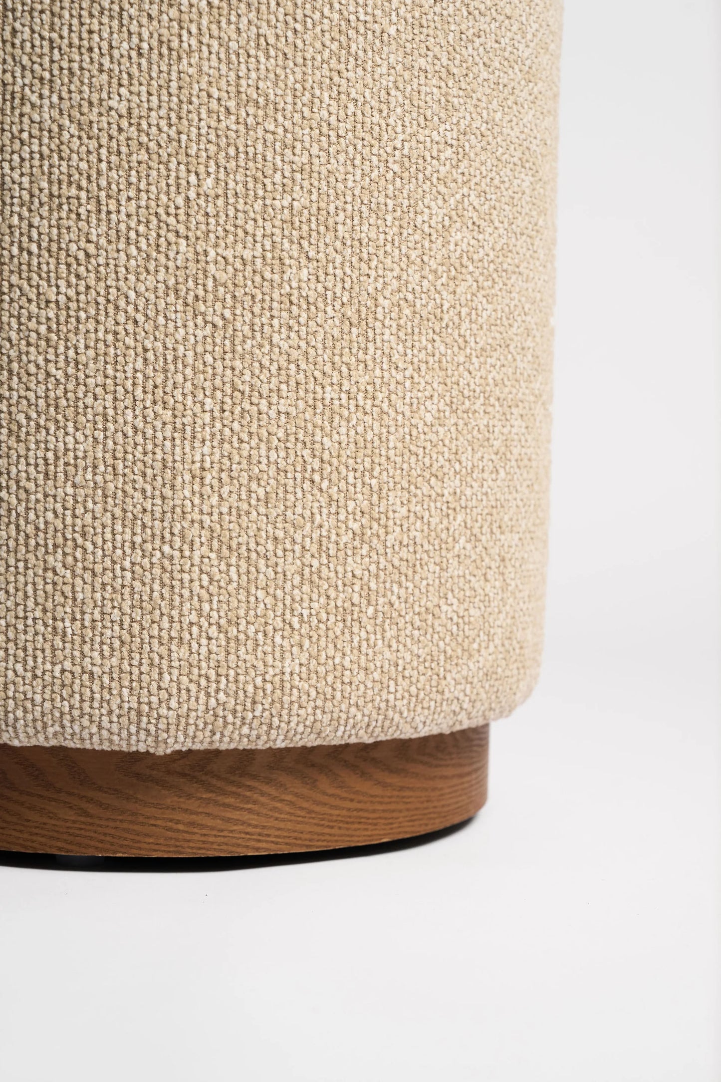 Close-up of a textured cylindrical object with wooden base on a white background