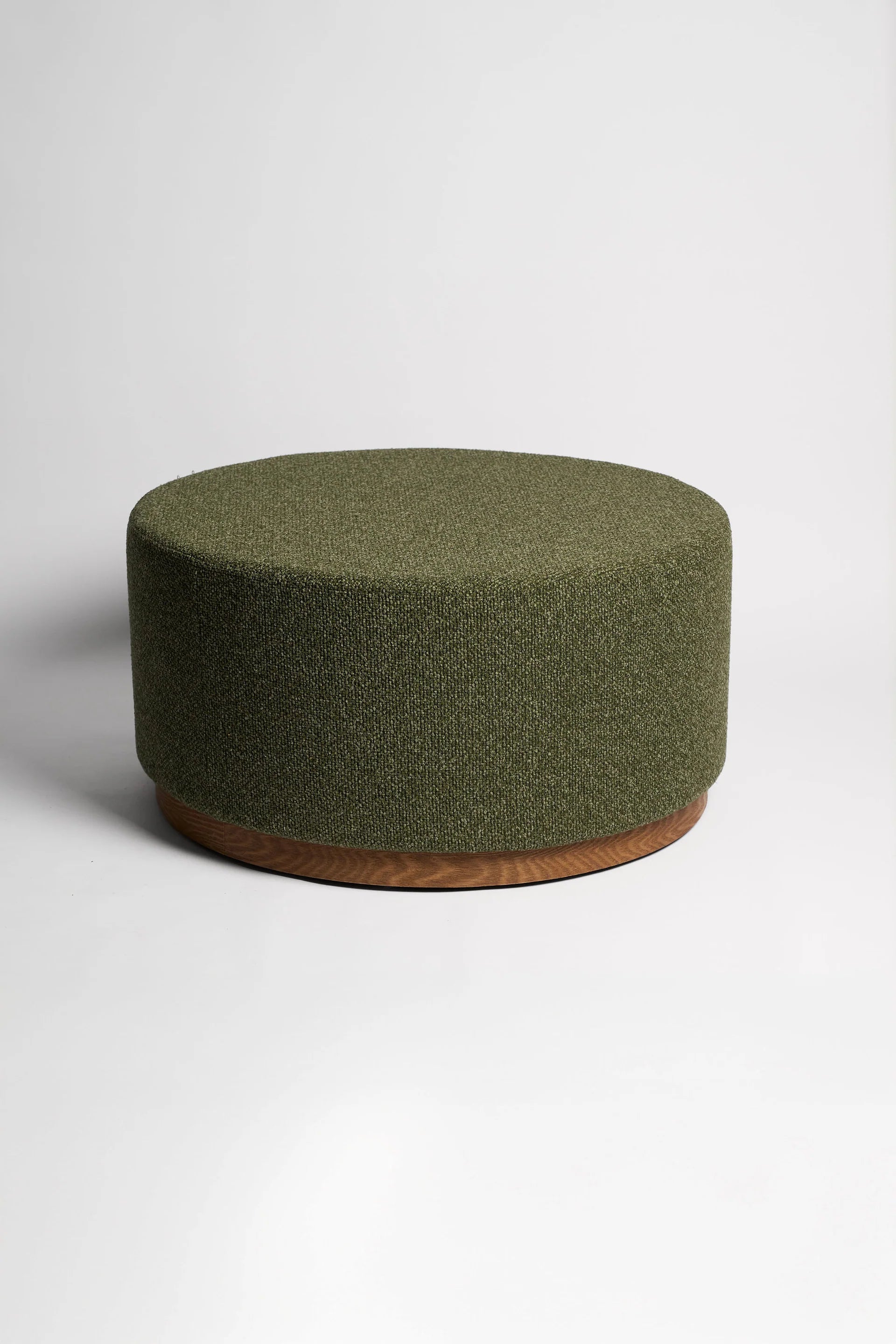 Green ottoman with a wooden base on a white background