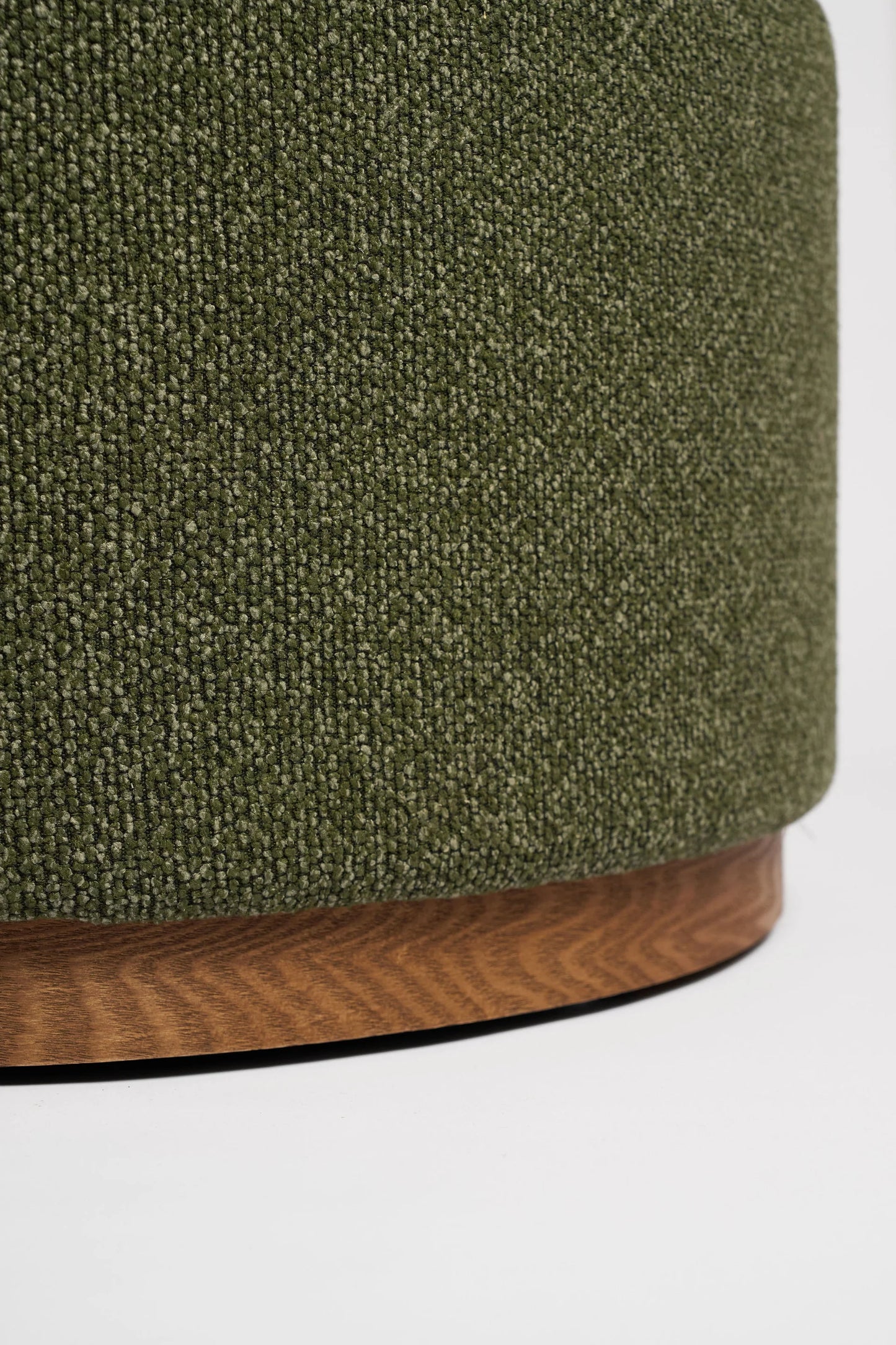 Close-up of a green textured ottoman with a wooden base on a white background