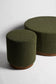 Two green cylindrical ottomans on a white background