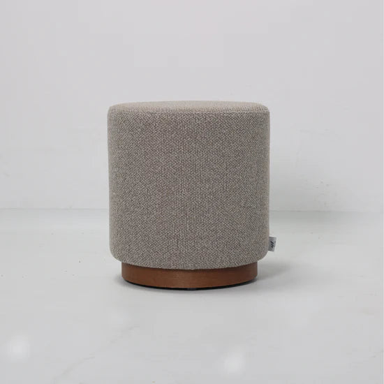 Round gray ottoman with a brown base on a light gray background