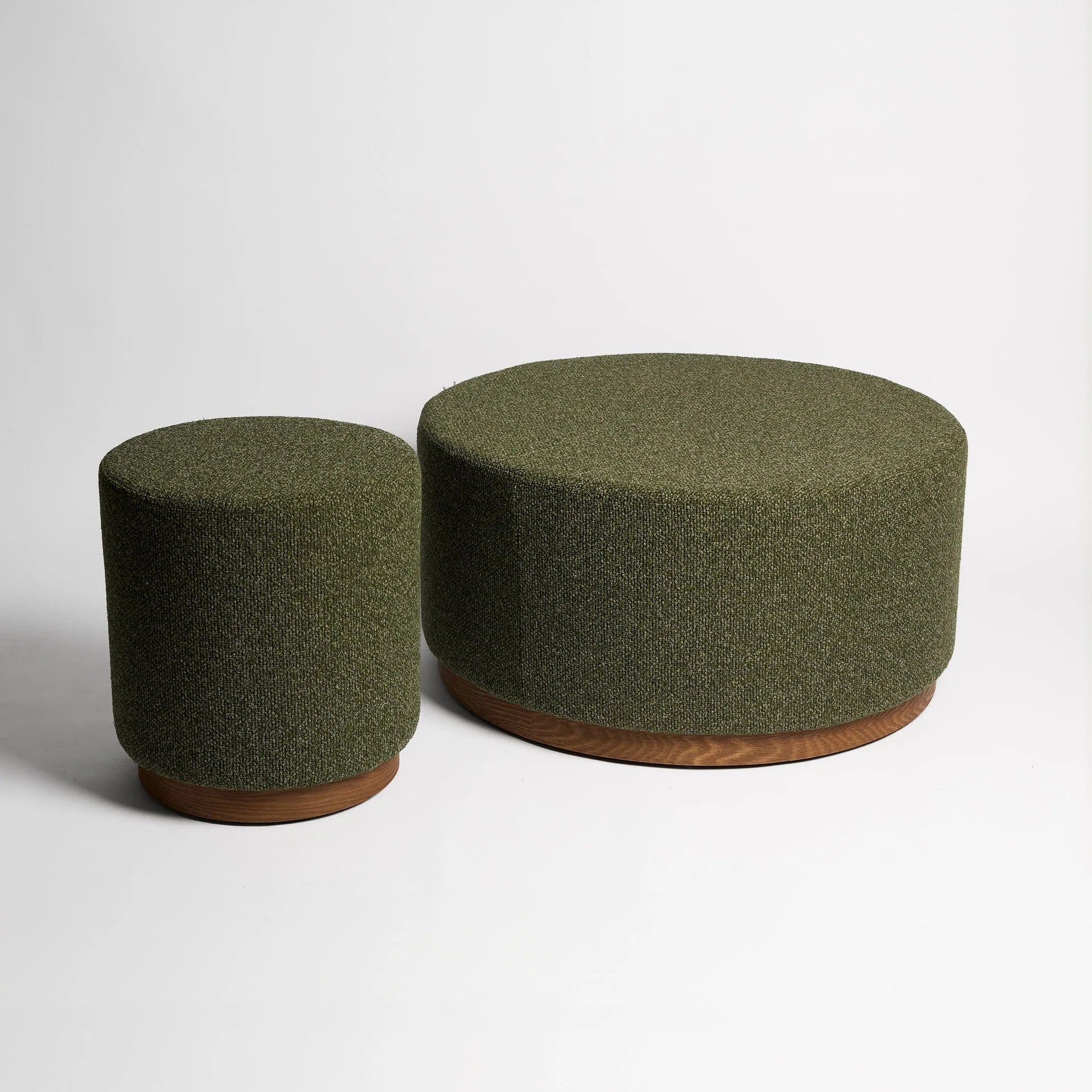Two green cylindrical stools on a white background