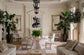 Elegant living room with white furniture, plants, and decorative elements.