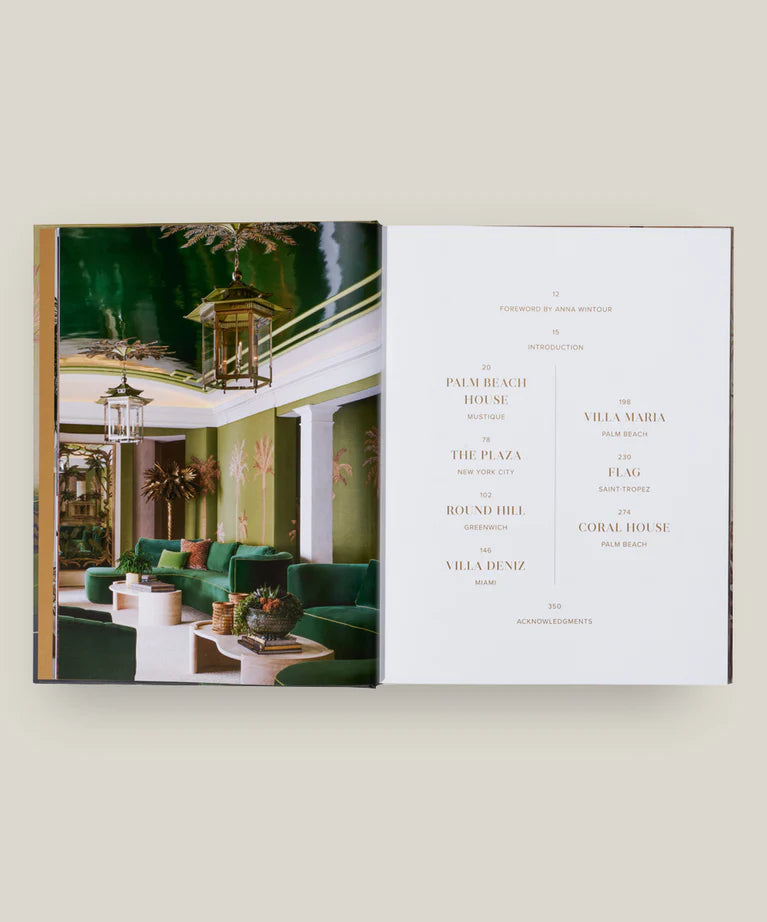 Open book showing a luxurious interior design layout with green sofas and chandeliers.