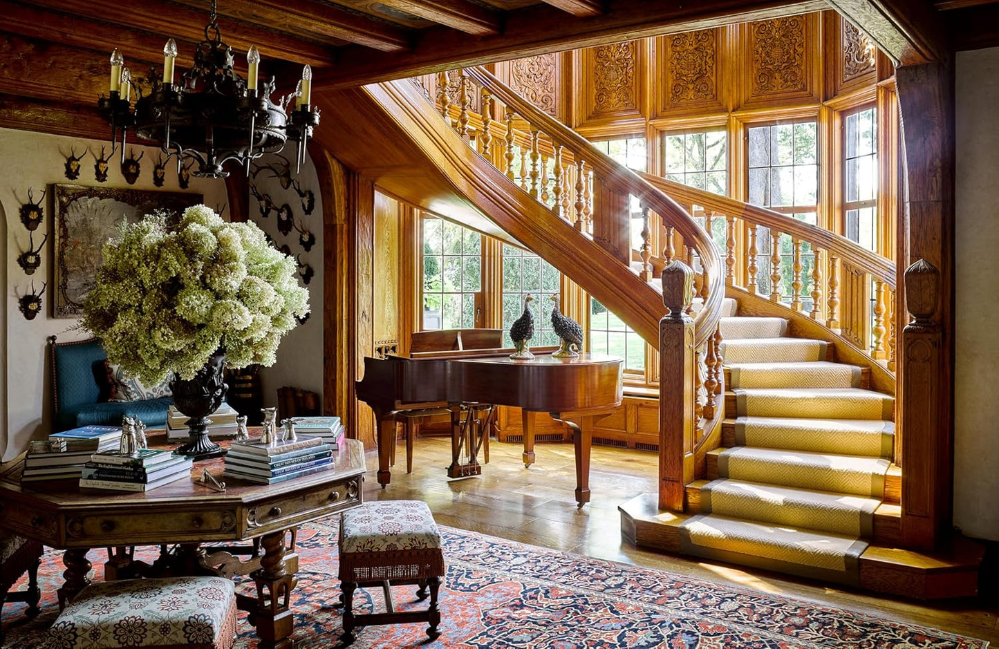 Grand staircase in a luxurious room with wooden paneling and decorative elements.