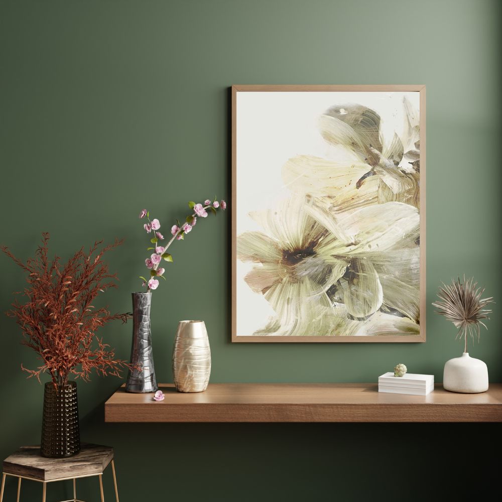 Framed floral artwork on a wall with decorative vases and plants below.