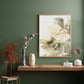 Framed floral artwork on a wall with decorative vases and plants below.