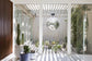 Modern interior with glass walls, plants, and a decorative mirror.
