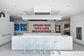 Modern kitchen with a quote on the wall, featuring white cabinetry and a central island.