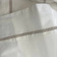 Close-up of a white garment with a zipper detail