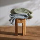 2 throws in green and blue on a wooden stool