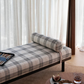 Plaid bed with a pillow and a lamp in a room with white curtains