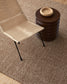 Beige chair and brown ottoman on a textured brown floor