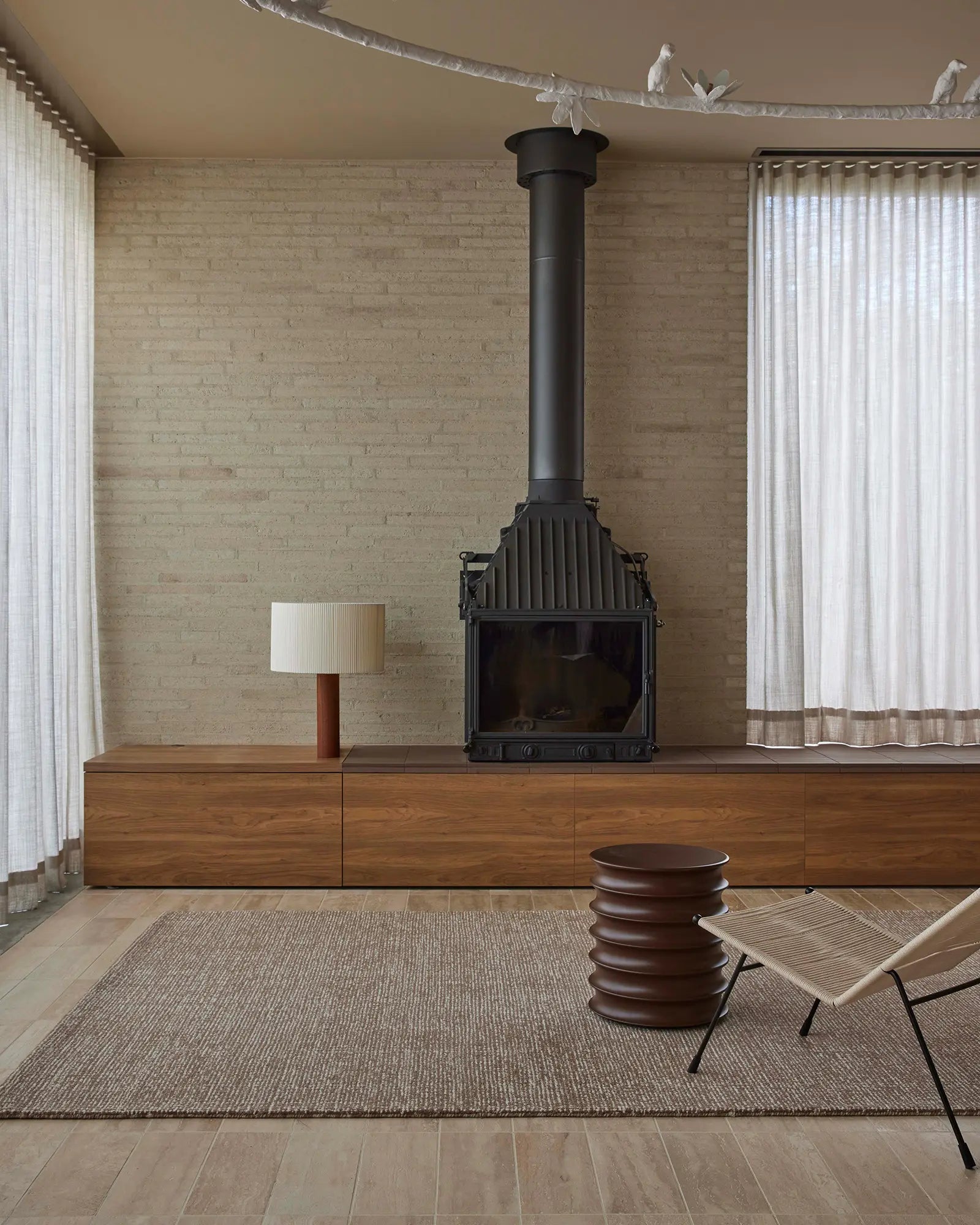 Modern living room with a fireplace, wooden cabinet, and minimal decor.