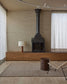 Modern living room with a fireplace, wooden cabinet, and minimal decor.