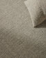 Close-up of a textured beige carpet with a folded corner.