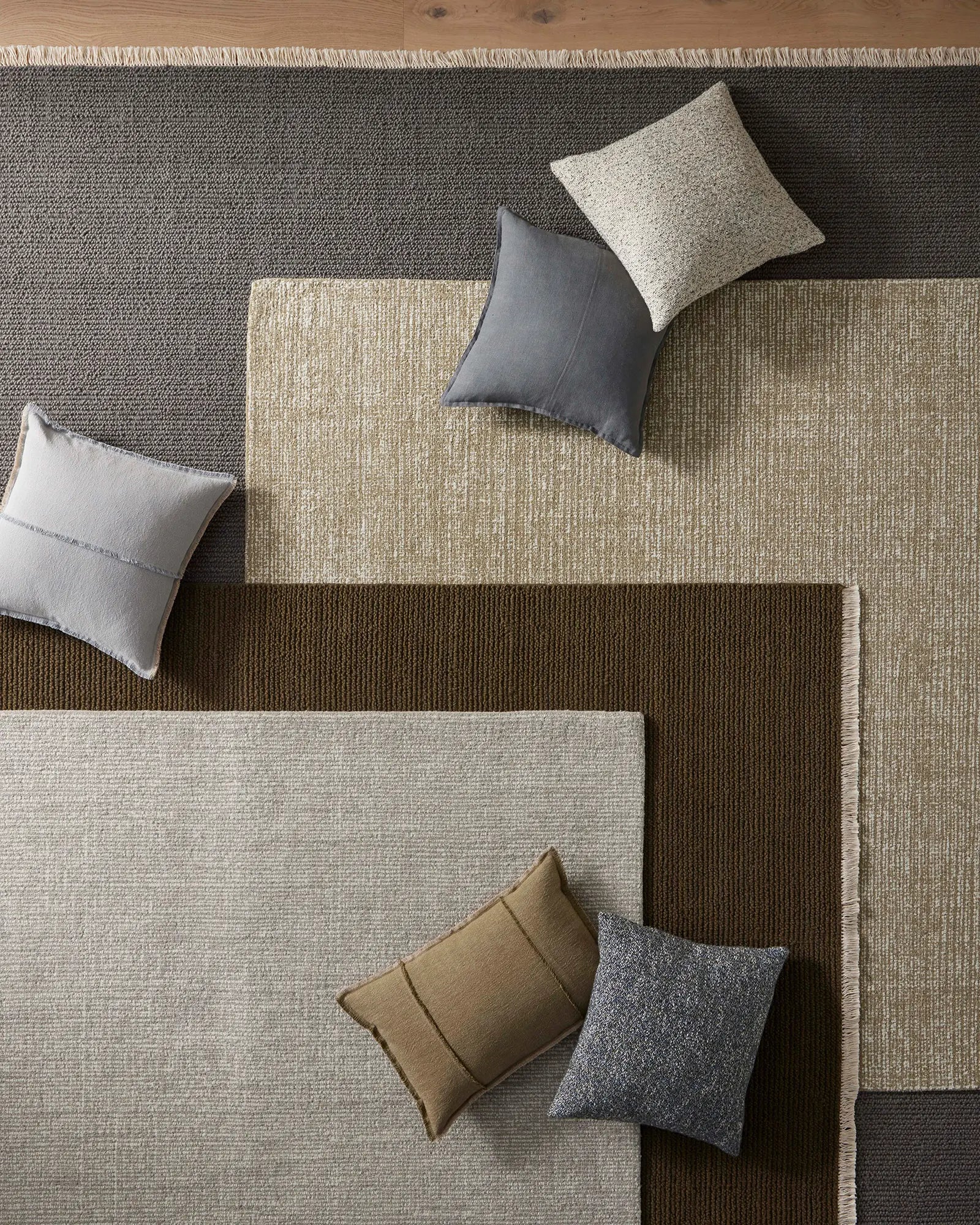 Colorful pillows on a textured rug with geometric pattern