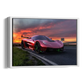 A framed wall art print showing a red supercar on a road at sunset, displayed against a plain white background.