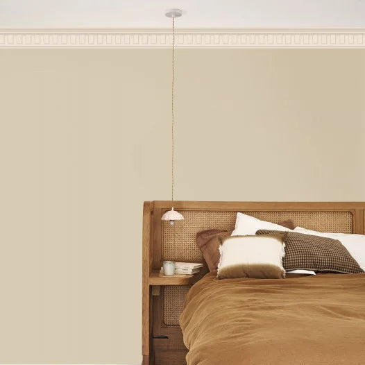 Bedroom with wooden headboard and nightstand against a beige wall