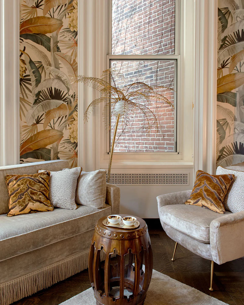 Living room with patterned wallpaper, sofa, armchair, and wooden side table.