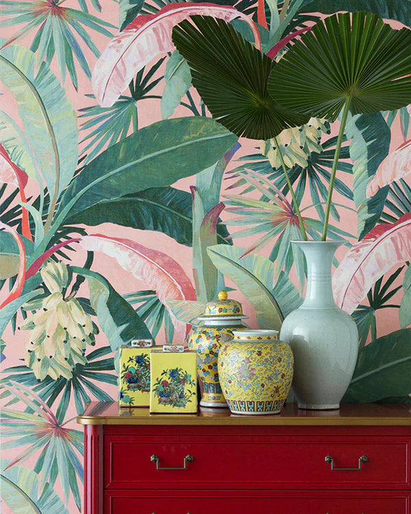 Decorative vases on a red cabinet with tropical leaf wallpaper