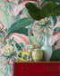 Decorative vases on a red cabinet with tropical leaf wallpaper