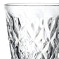 A close-up of a clear cut-glass tumbler with an intricate geometric pattern, shown against a plain white background.