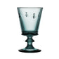 Blue glass goblet with engraved designs on a white background