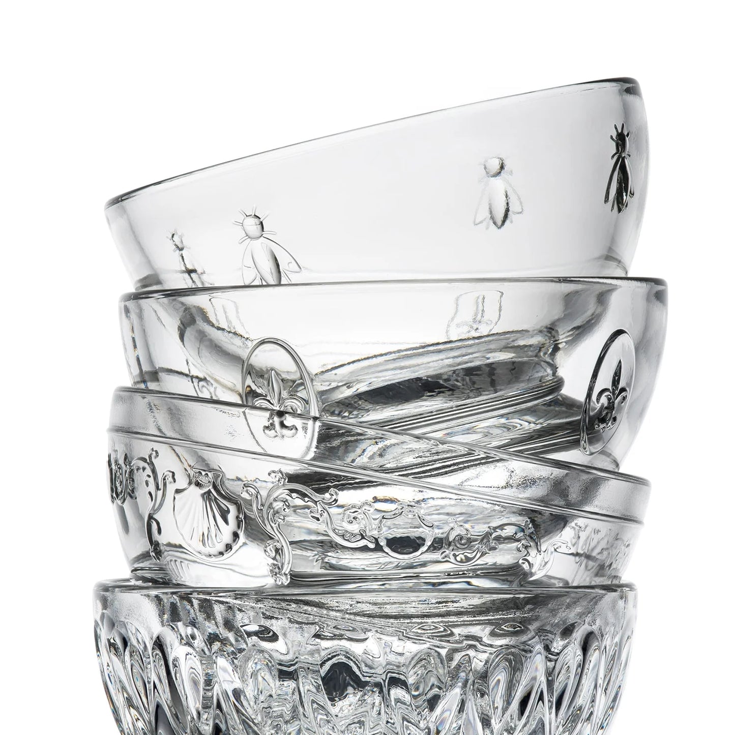 Stack of clear glass tumblers with embossed designs on a white background