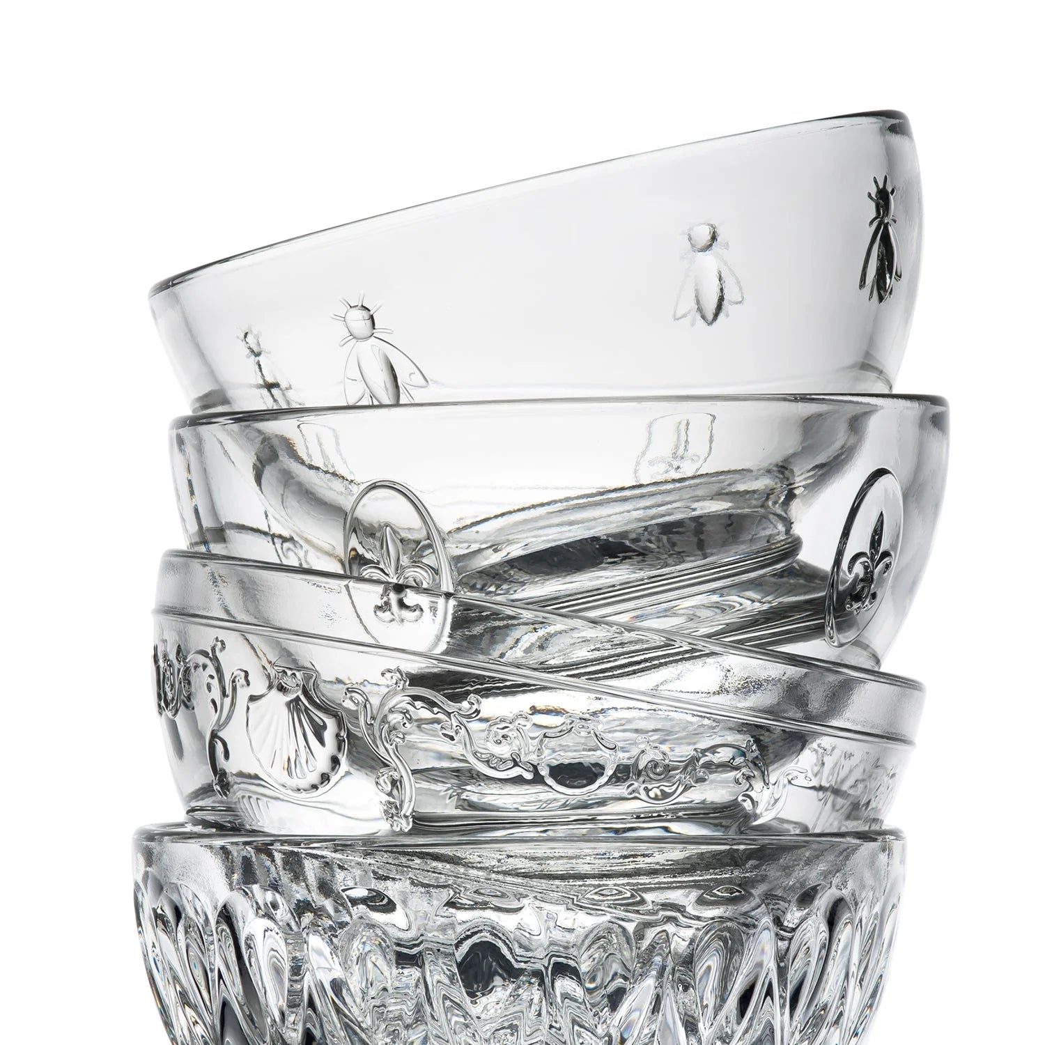 Stack of clear glass tumblers with embossed designs on a white background