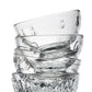 Stack of clear glass tumblers with embossed designs on a white background