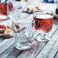 Two glasses of red wine on a wooden table with appetizers