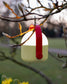 Outdoor lamp with red handle hanging on a winter tree in bud