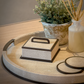 Decorative items including a box, plant, and vase on a wooden surface with a neutral background.