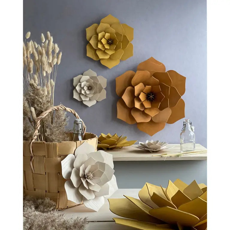 Decorative wooden  flowers in various colors on a wall and surface.