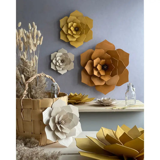 Decorative wooden  flowers in various colors on a wall and surface.