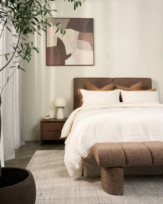 Modern bedroom with a bed, nightstand, and abstract art on the wall.