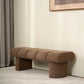 Brown textured bench against a neutral wall with a light gray carpet.