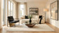 Modern living room with a sofa, armchair, coffee table, and decorative elements.