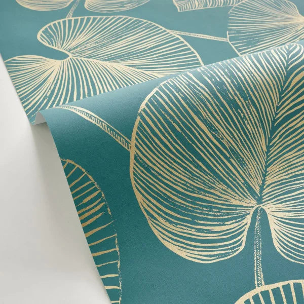 Teal wallpaper with a cream-colored botanical leaf pattern, shown partially unrolled on a white surface.