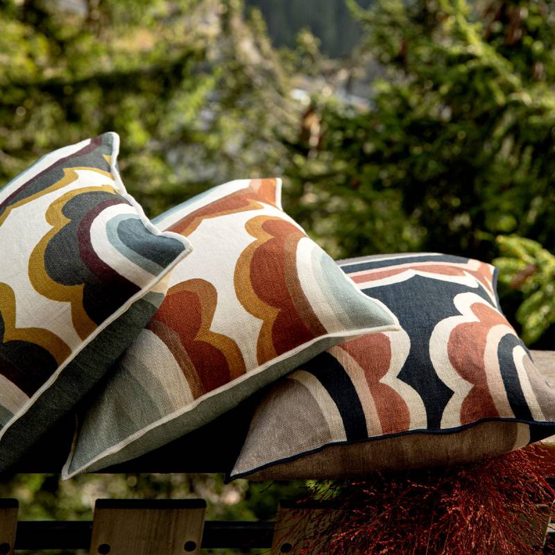 3 marguerite cushions lying down on a wooden fence in 3 different colours of a nail floral patter