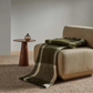 Checked Mayfield throw in olive and cream draped over a beige sofa chair with a small wooden side table and vase