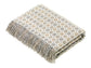 Folded Milan merino throw with a pattern and fringes on a white background
