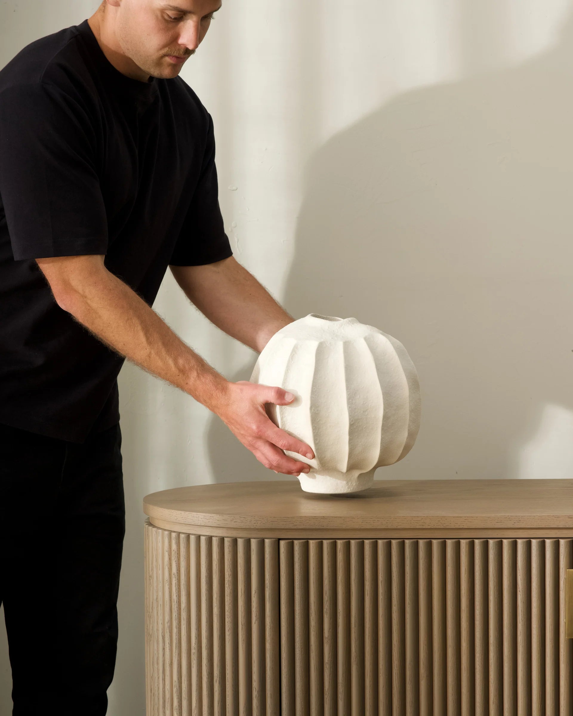 Person interacting with a white textured object on a wooden surface