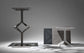 Three modern metal tables with geometric designs on a gray background