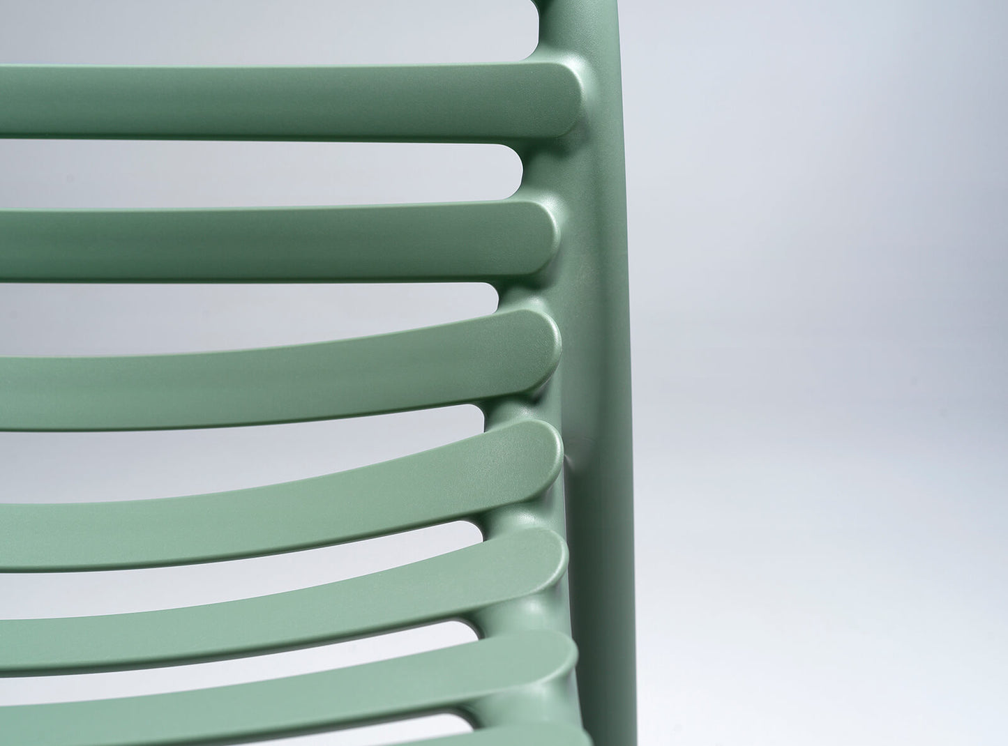 Green slatted chair against a light gray background