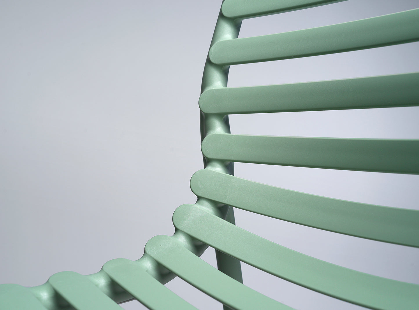 Close-up of a light green chair with a plain background